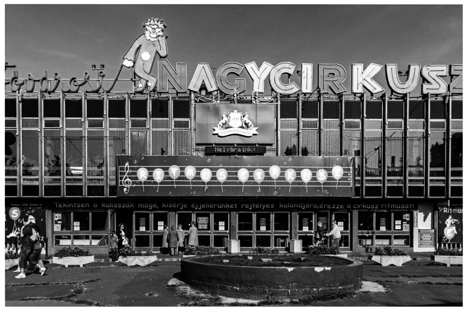 Gebäude "NAGYCIRKUSZ" mit Affenmotiv und Schaufenster, Menschen am Eingang.