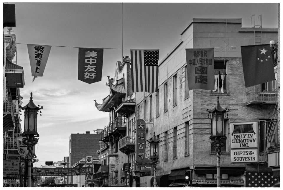Belebte Chinatown-Straße mit traditionellen Gebäuden, Laternen und chinesischen Schriftzeichen.