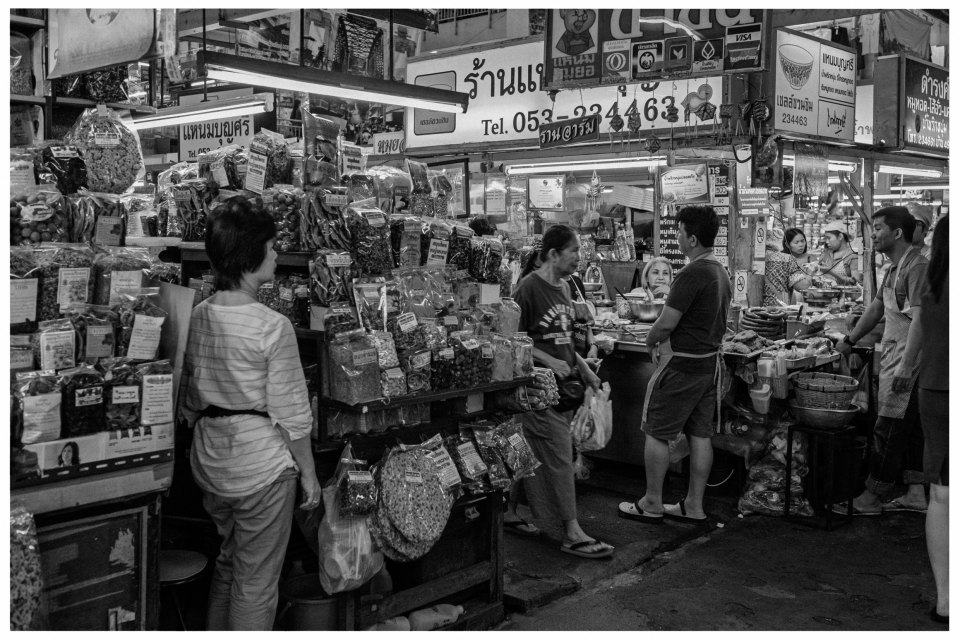 Marktplatz mit Ständen, die getrocknete Waren verkaufen, Personen interagieren lebendig.
